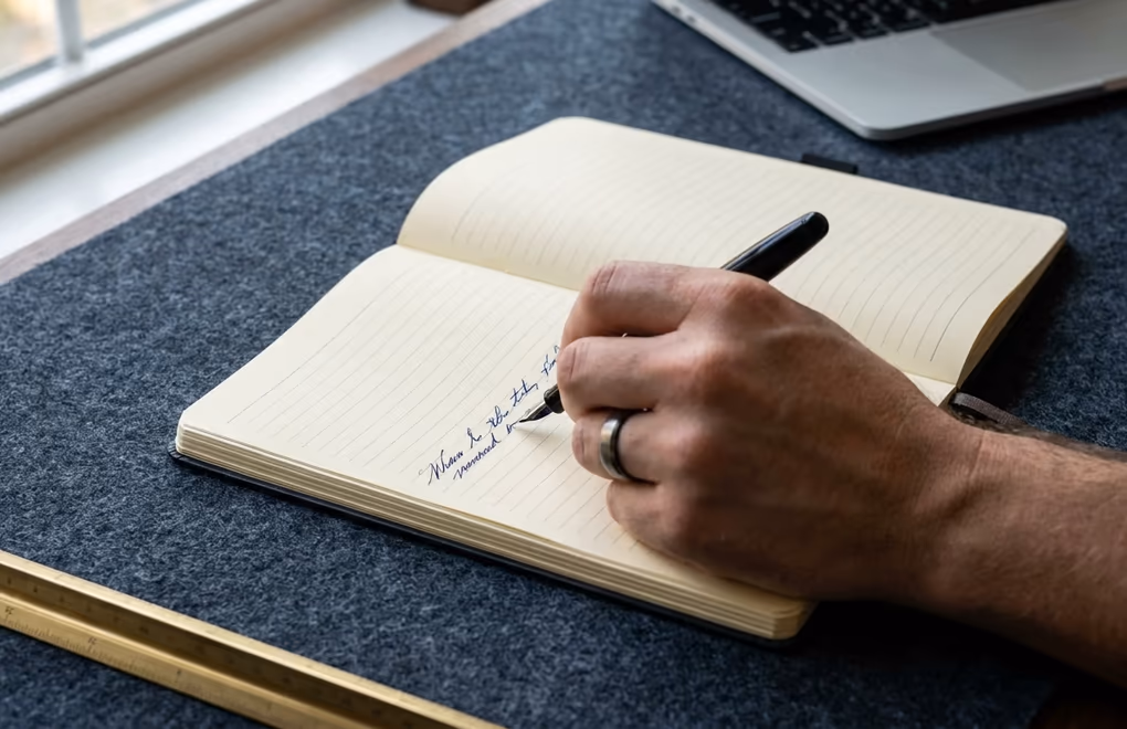 Working out the three-year cost of a course platform by hand in a notebook
